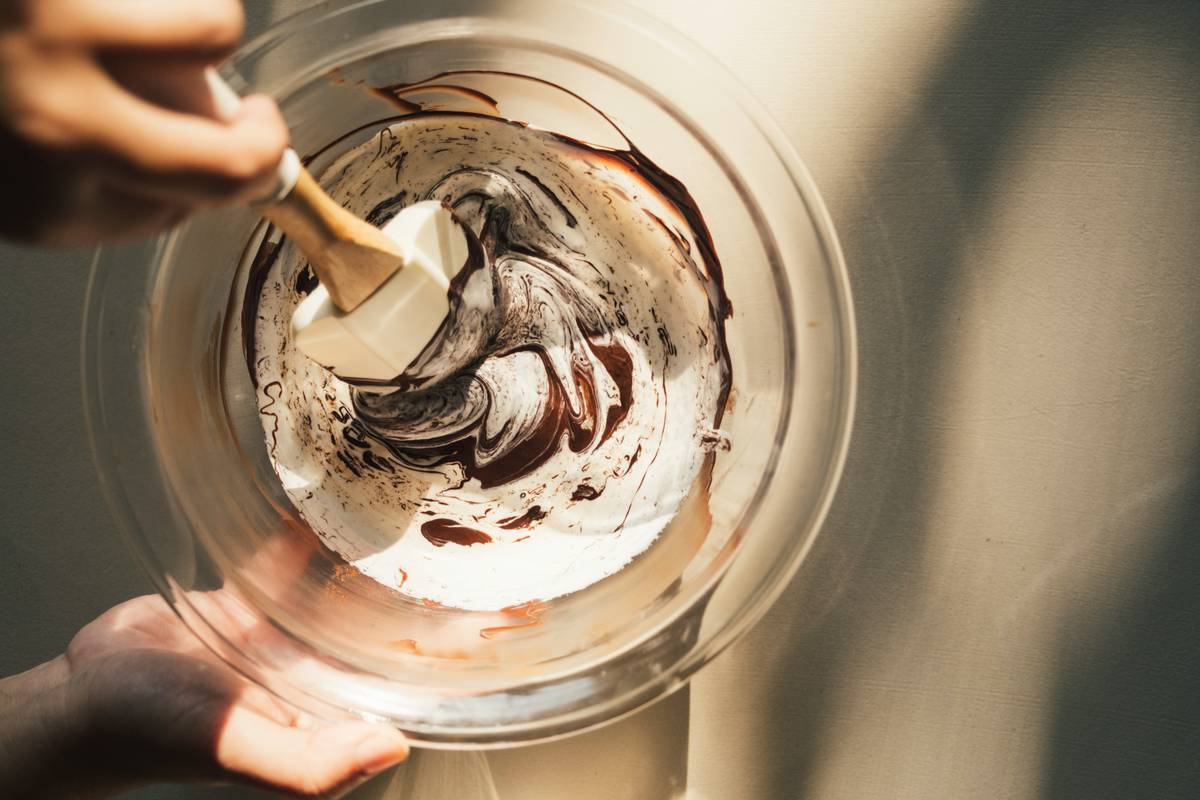 A stainless-steel yogurt maker on a granite countertop beside open jars of creamy yogurt and fresh berries — benefits from eating yogurt